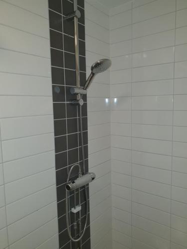 a shower with a shower head in a bathroom at Ariston Hotell in Lidingö