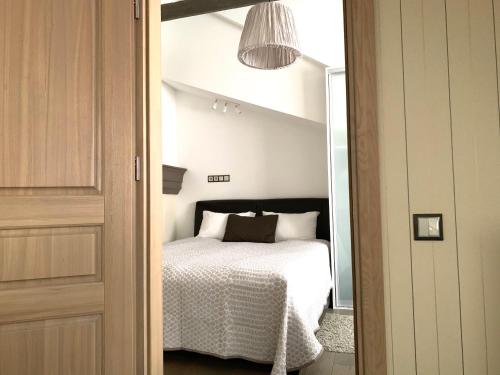 a bedroom with a bed with white sheets and a lamp at Very Vilnius Pilies street in Vilnius