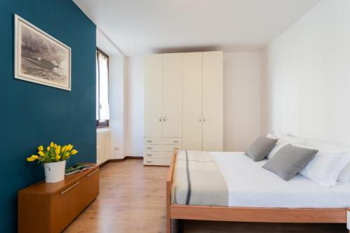 a bedroom with a bed and a blue wall at Family Lake Apartment by Rent All Como in Mezzegra