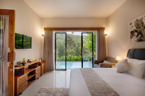 a bedroom with a bed and a sliding glass door at Nadira Bali Villa in Munduk