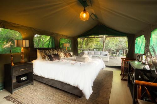 a bedroom with a bed in a tent at Camp Bethel in Hoedspruit