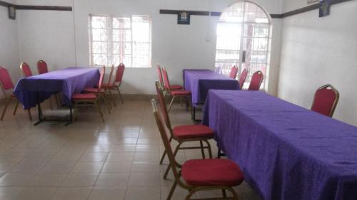ein Esszimmer mit blauen Tischen und roten Stühlen in der Unterkunft Rest Gardens Ltd in Kampala
