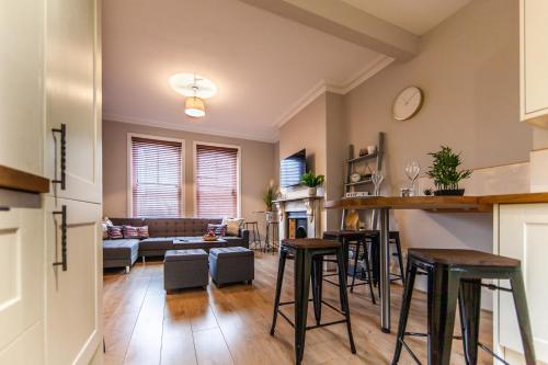 a kitchen and living room with bar stools at Large House - Contractors & Families & Private Parking in Northampton