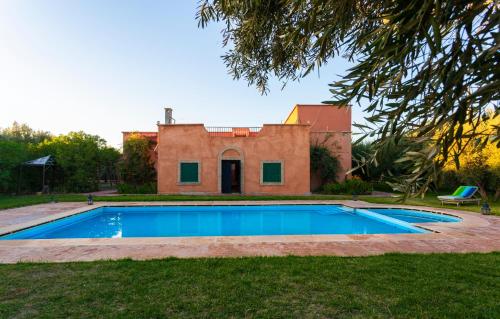 une maison avec une piscine dans la cour dans l'établissement Riad Oussari, à Marrakech