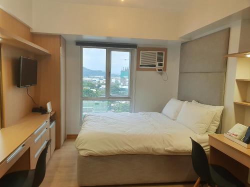 a hotel room with a bed and a window at Steff's Condo 816 at Centrio Tower in Cagayan de Oro
