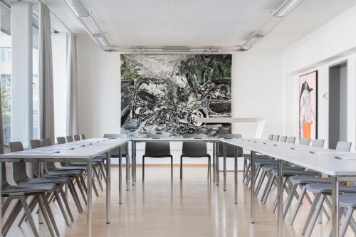 a room filled with tables, chairs, and tables at Augarten Art Hotel in Graz