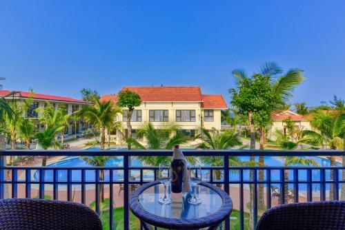 a table on a balcony with a view of a resort at MANLI Resort Quảng Bình in Dong Hoi