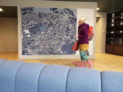 a woman is standing in front of a large painting at Edinburgh Central Accommodation in Edinburgh