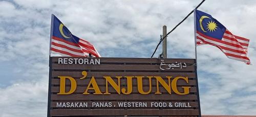 a sign for a restaurant with two flags on it at AK PERMATA HOMESTAY in Tanah Merah