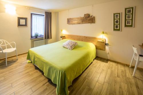 a bedroom with a bed and a table and chairs at La Pietra Felice in Introd