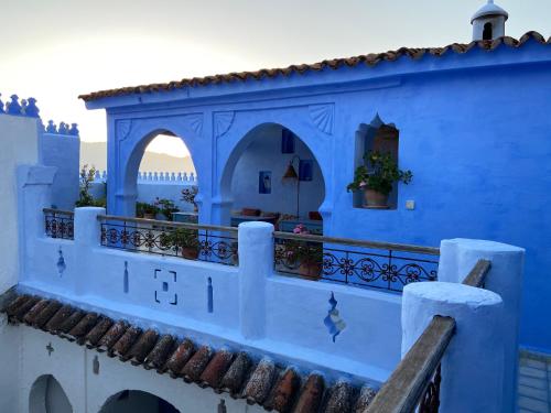 a building painted blue and white with a balcony at Casa Perleta in Chefchaouene