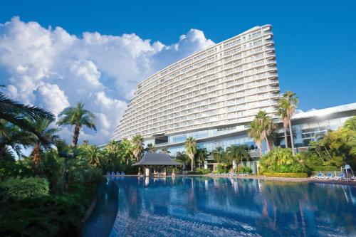 ein Hotel mit einem Pool vor einem Gebäude in der Unterkunft Xiamen International Conference Center Hotel Prime Seaview Hotel in Xiamen