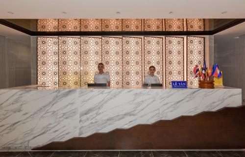a marble counter with two people in a room at MANLI Resort Quảng Bình in Dong Hoi