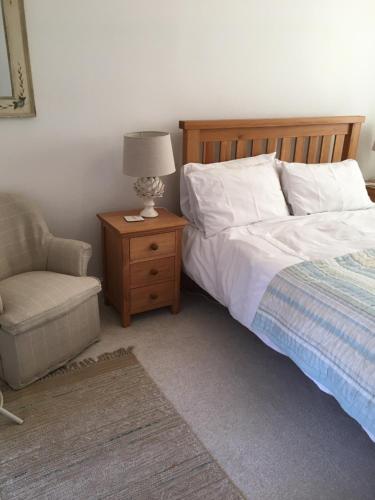 ein Schlafzimmer mit einem Bett, einem Stuhl und einer Lampe in der Unterkunft BELESME, PRIVATE ANNEX in Bridgnorth