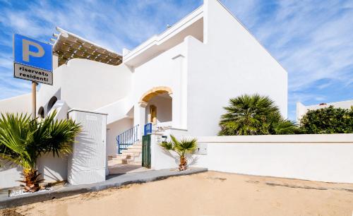 a white house with a street sign in front of it at Villetta Maredoro - Fronte Spiaggia Pescoluse in Marina di Pescoluse