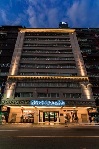 a tall building with lights on the front of it at Fish Hotel Kaohsiung in Kaohsiung
