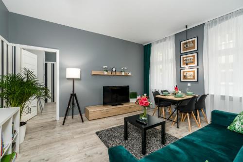 a living room with a blue couch and a table at Deluxe Old Town Apartment by Renters in Poznań