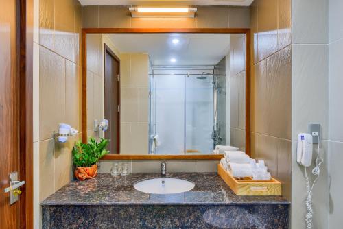 a bathroom with a sink and a shower and a mirror at MANLI Resort Quảng Bình in Dong Hoi