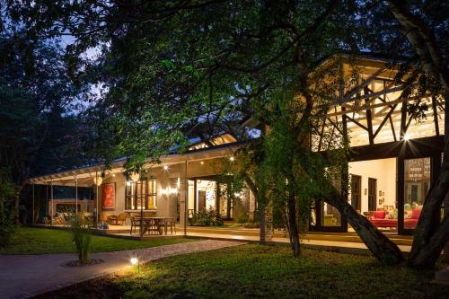 a house with a tree in front of it at Mbano Manor Hotel Victoria Falls in Victoria Falls