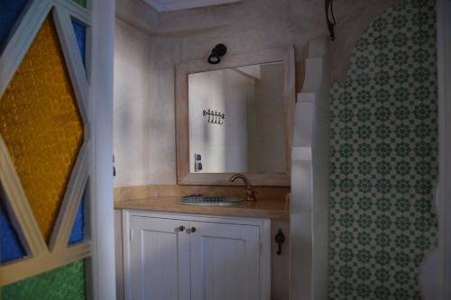 a bathroom with a sink and a mirror at Casa Perleta in Chefchaouene