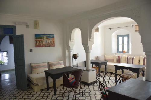 a living room with a couch and a table and chairs at Casa Perleta in Chefchaouene