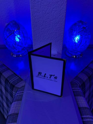 a room with two blue lights and a picture on a bed at The Danescourt in Blackpool