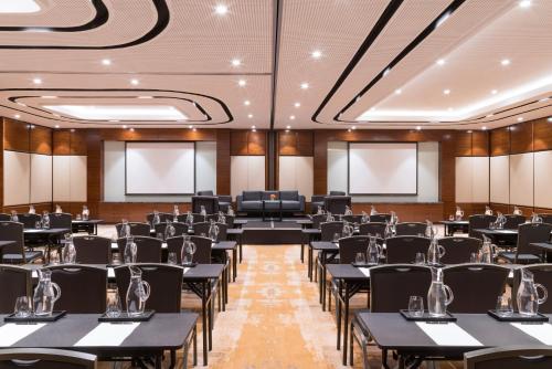 a conference room with black tables and chairs at Swissôtel Jakarta PIK Avenue in Jakarta