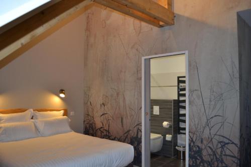 A bed or beds in a room at Logis Auberge de Pont Calleck