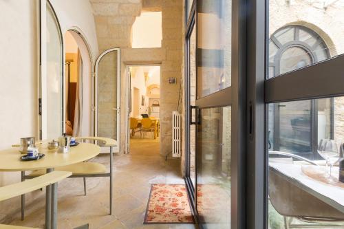una camera con tavolo, sedie e finestra di Appartamento Ai Fiorentini by BarbarHouse a Lecce