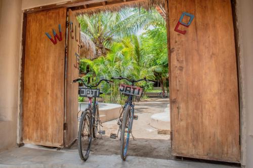 two bikes parked in front of an open door at Jati Village, Party Hostel and Bungalows in Gili Trawangan