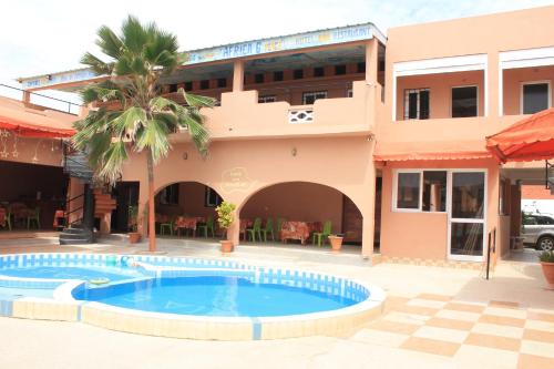 un complejo con piscina frente a un edificio en Africa 6 Plage, en Somone
