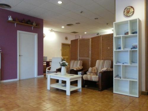 a living room with a couch and a table and chairs at Pensión Pamplonabeds in Pamplona