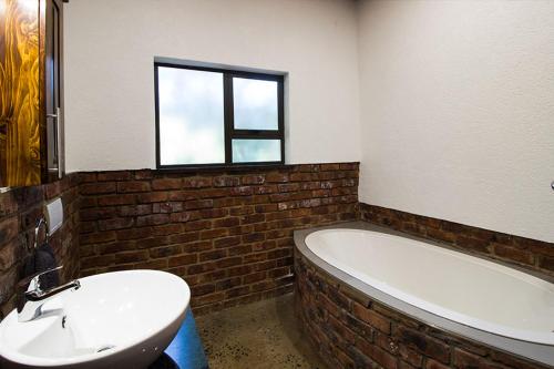 a bathroom with a white tub and a sink and a window at Stephan's Guest House in Port Shepstone
