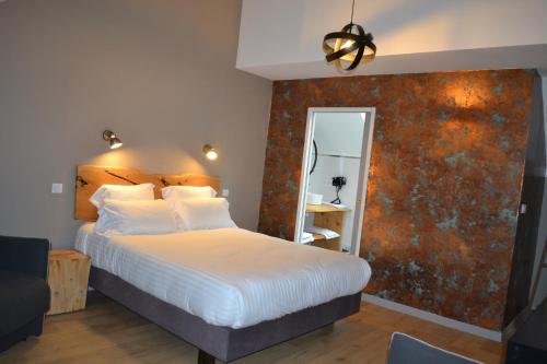 a bedroom with a large bed and a mirror at Logis Auberge de Pont Calleck in Inguiniel