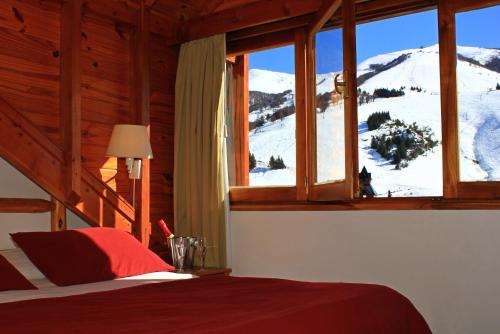 a bedroom with a bed and a window with a snow covered mountain at Club Hotel Catedral in San Carlos de Bariloche