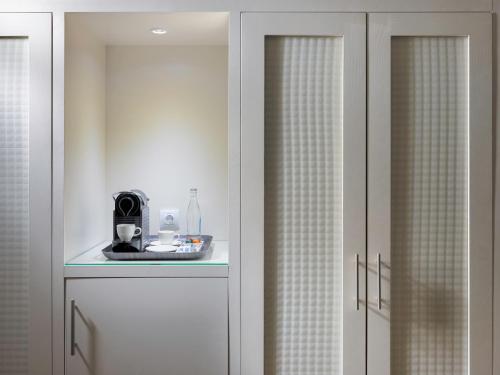 a pair of white wardrobes with glass doors at Boutique Hotel H10 White Suites - Adults Only in Playa Blanca