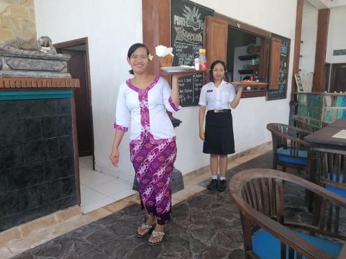 two women are standing in a restaurant at Puri Oka Beach Bungalows in Candidasa