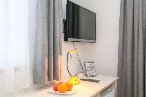 a room with a tv and a table with fruit on it at Hotel Sonnenhof - bed & breakfast & appartements in Innsbruck