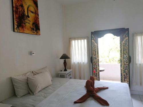 a figurine sitting on a bed in a bedroom at Puri Oka Beach Bungalows in Candidasa