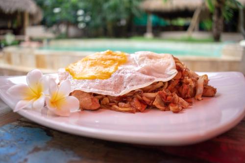 a plate of food with an egg on top at Jati Village, Party Hostel and Bungalows in Gili Trawangan
