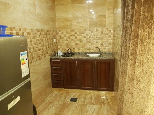 ein Bad mit einem Waschbecken und einem Kühlschrank in der Unterkunft Siveen Hotel in Amman