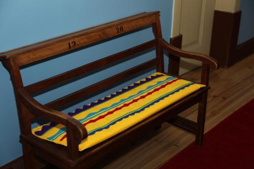 a wooden bench with a colorful cushion on it at CSI Coimbra & Guest House - Student accommodation in Coimbra
