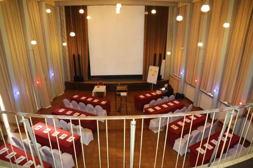 a meeting room with red and white chairs and a screen at Schlosshotel Domäne Walberberg in Bornheim