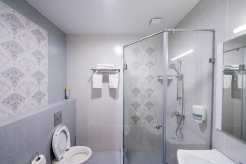 a bathroom with a shower and a toilet and a sink at Oasis Residence in Bishkek