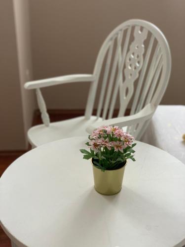 a white table with a flower pot on a chair at Apartments Kristina in Klenovica