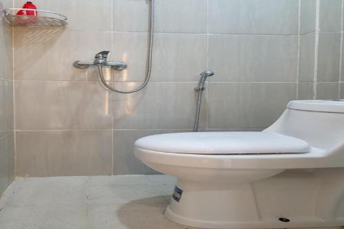 a bathroom with a toilet and a shower at RedDoorz near RSUD Kota Luwuk in Luwuk