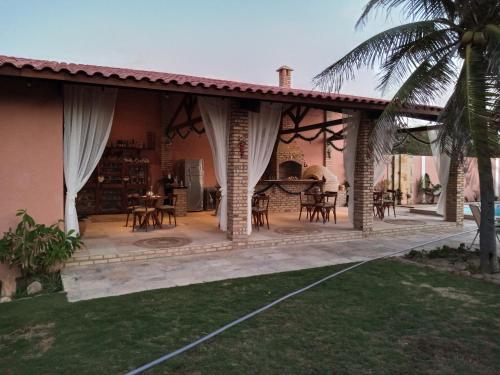 eine Terrasse mit Tischen und Stühlen auf einem Haus in der Unterkunft Villa Bianca Suítes in Beberibe