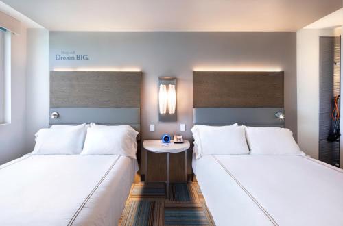 a hotel room with two beds and a table at EVEN Hotel Miami - Airport by IHG in Miami