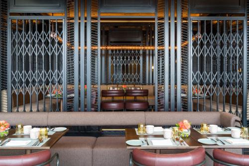 a restaurant with two tables and chairs and a bench at Swissôtel Jakarta PIK Avenue in Jakarta