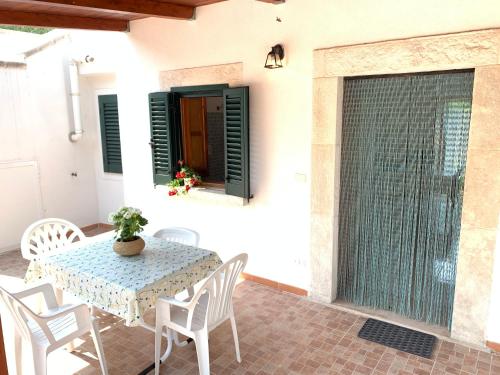 d'une terrasse avec une table, des chaises et une fenêtre. dans l'établissement Casa del gelso, à San Menaio